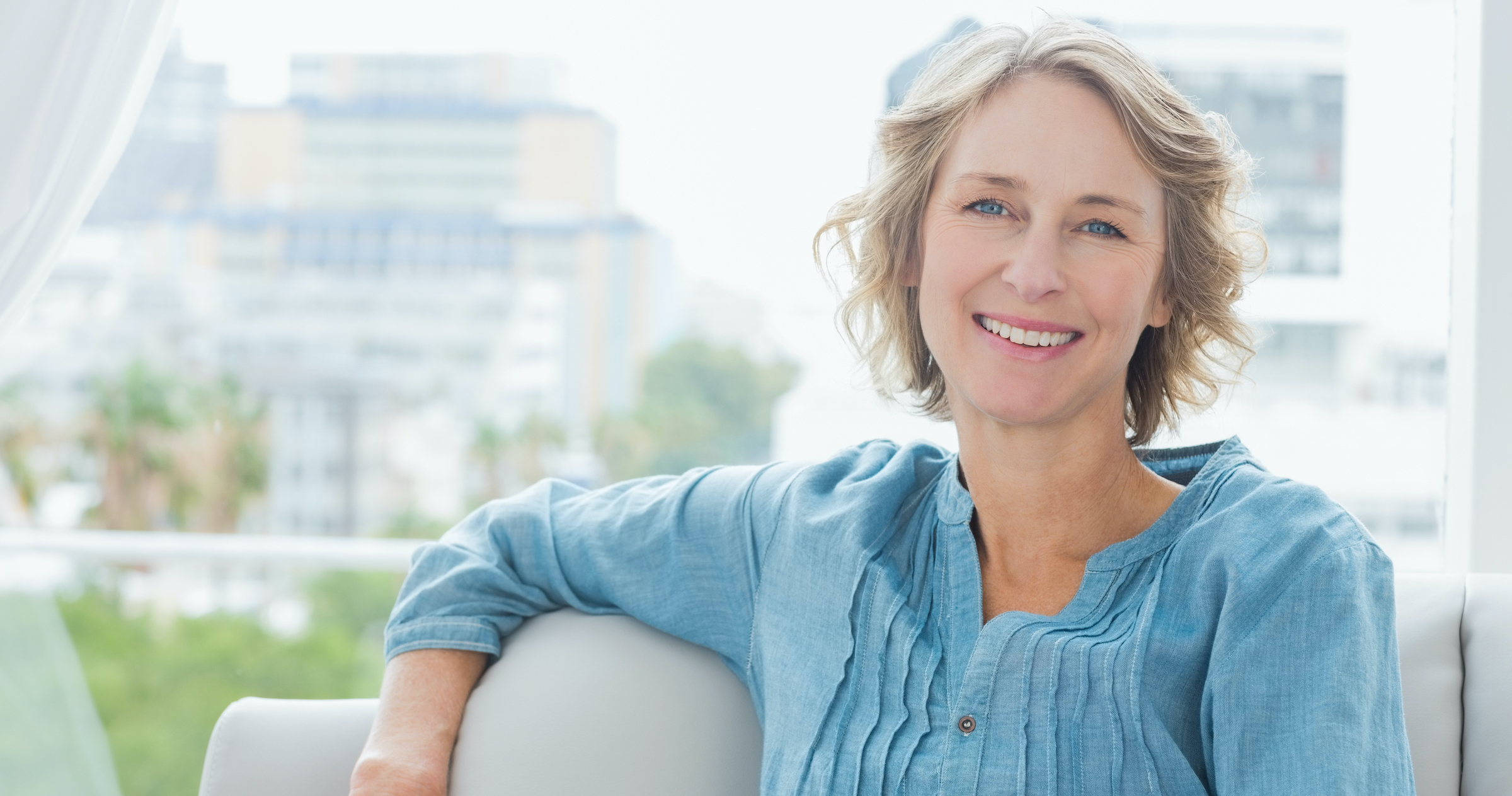 Happy woman relaxing on her couch at home in the sitting room